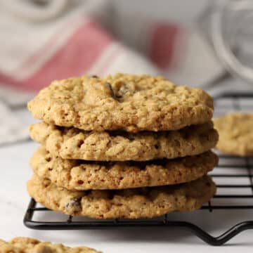 A stack of oatmeal raisin cookies on a cooling rack.