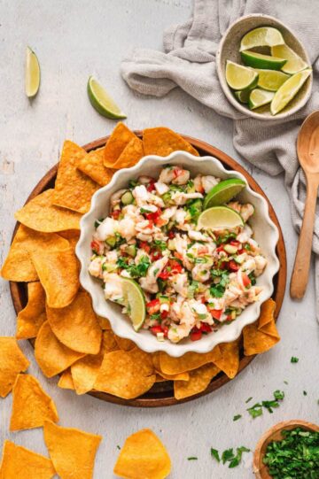 A bowl of ceviche surrounded by seasoned chips.