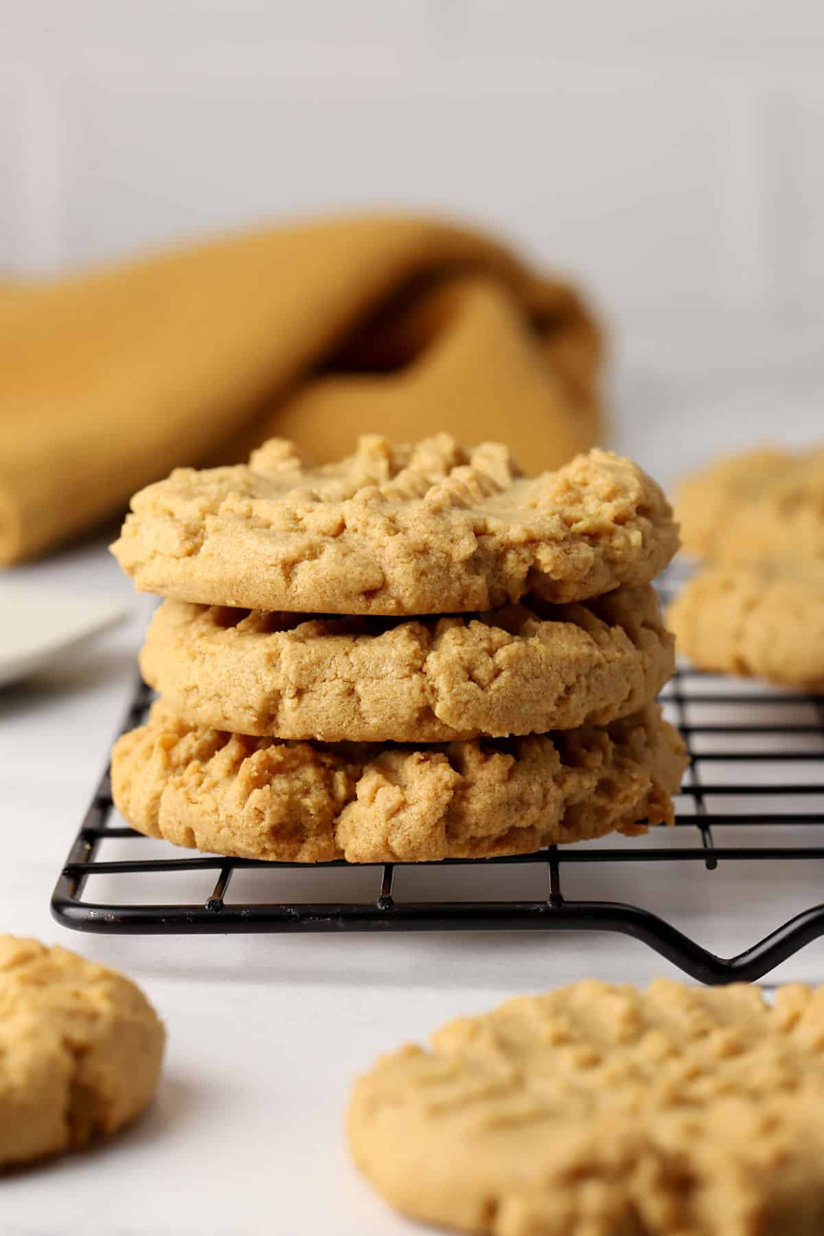 A stack of three cookies on a cooling rack.
