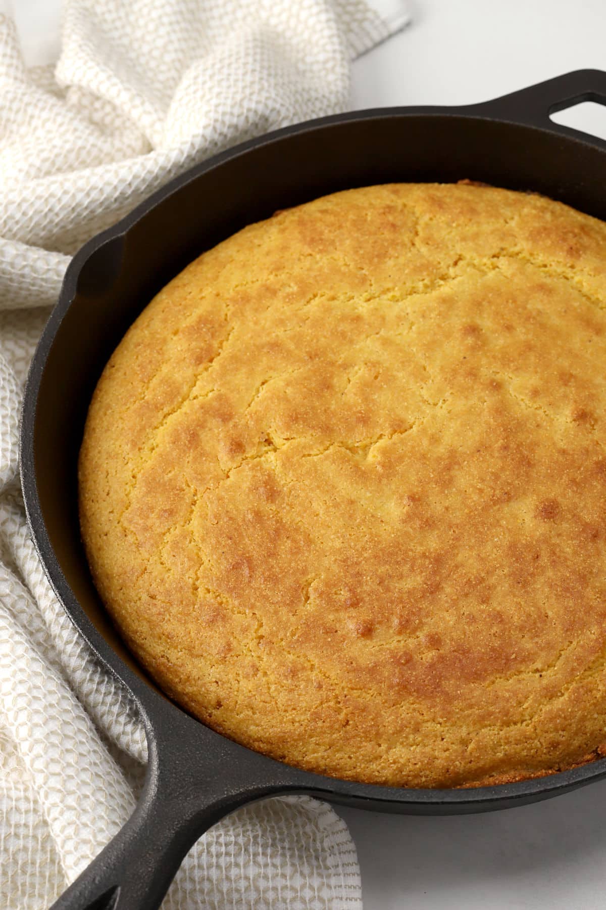 Cast iron skillet filled with baked cornbread.