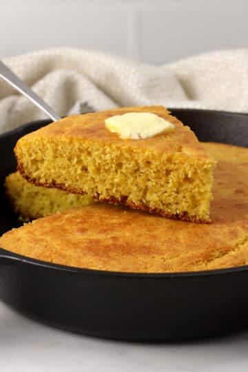 Slice of cornbread with butter on top.