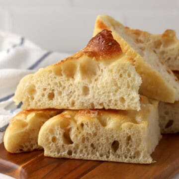 Wedges of focaccia on a cutting board.