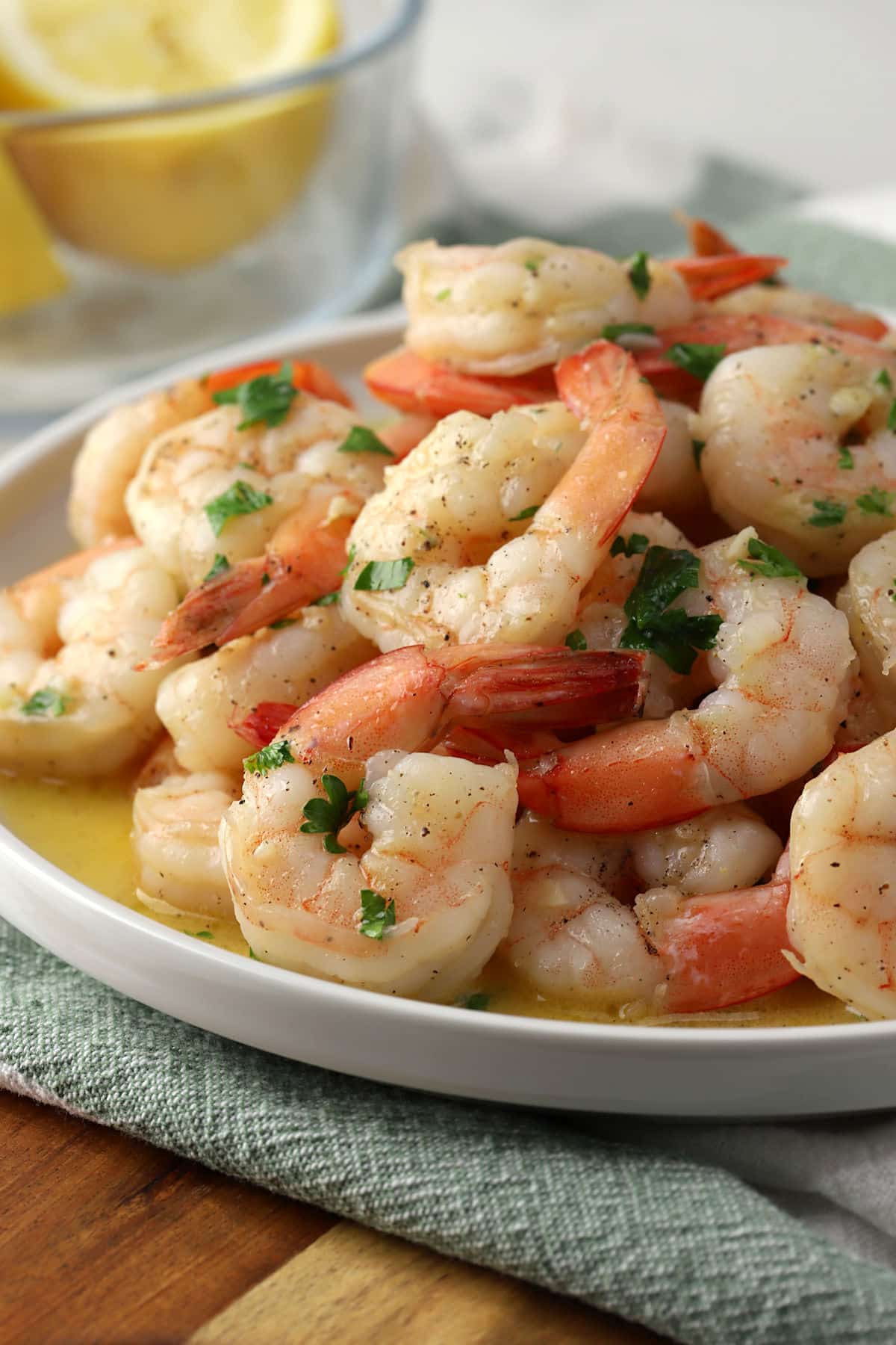 Closeup of garlic butter shrimp garnished with parsley on a plate.
