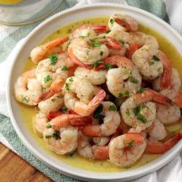 A round plate filled with garlic butter shrimp.