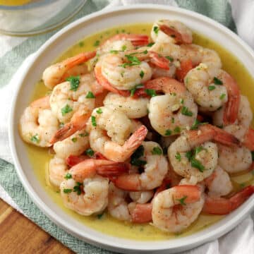 A round plate filled with garlic butter shrimp.