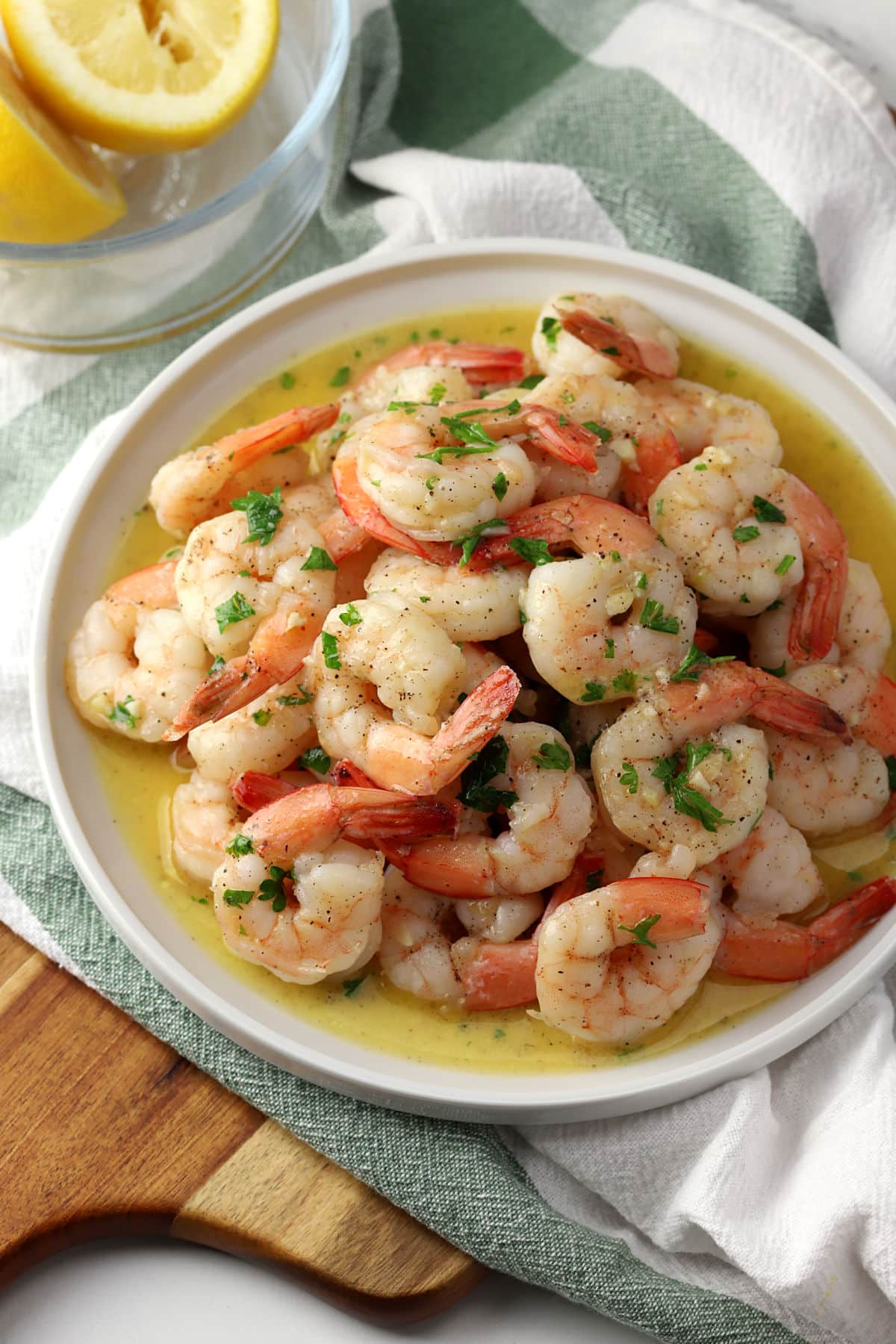 A round plate filled with garlic butter shrimp.