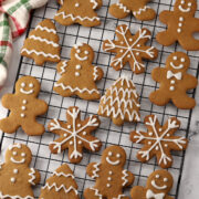 A variety of gingerbread cookies on a cooling rack.