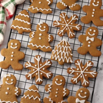 A variety of gingerbread cookies on a cooling rack.