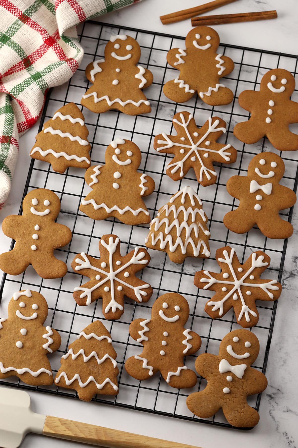 A variety of gingerbread cookies on a cooling rack.