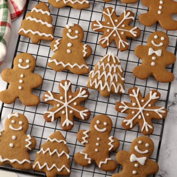 A variety of gingerbread cookies on a cooling rack.