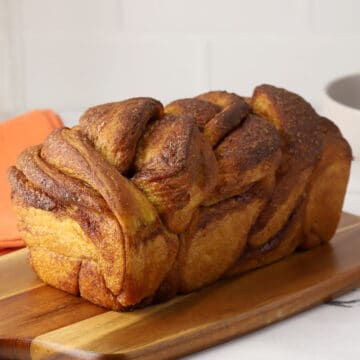 A loaf of pumpkin babka on a cutting board.