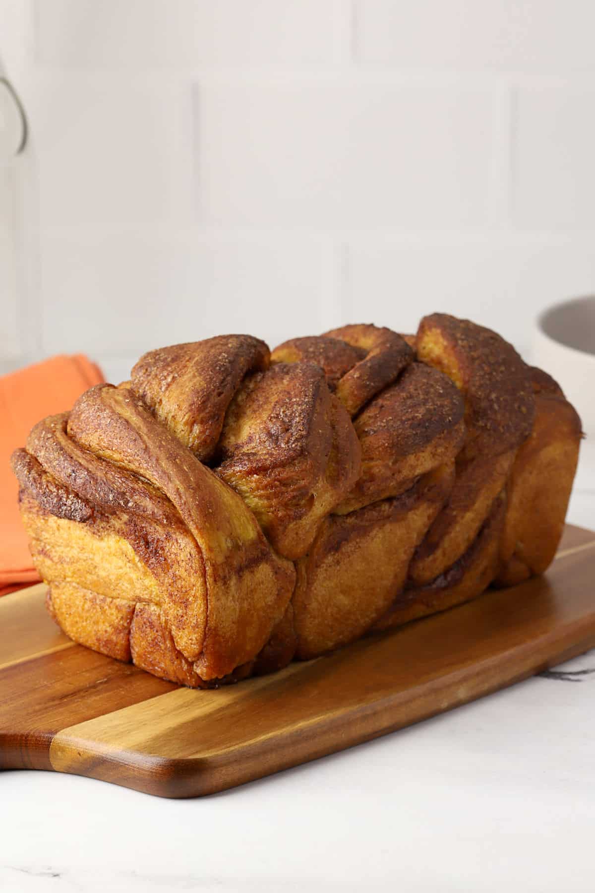 A loaf of pumpkin babka on a cutting board.